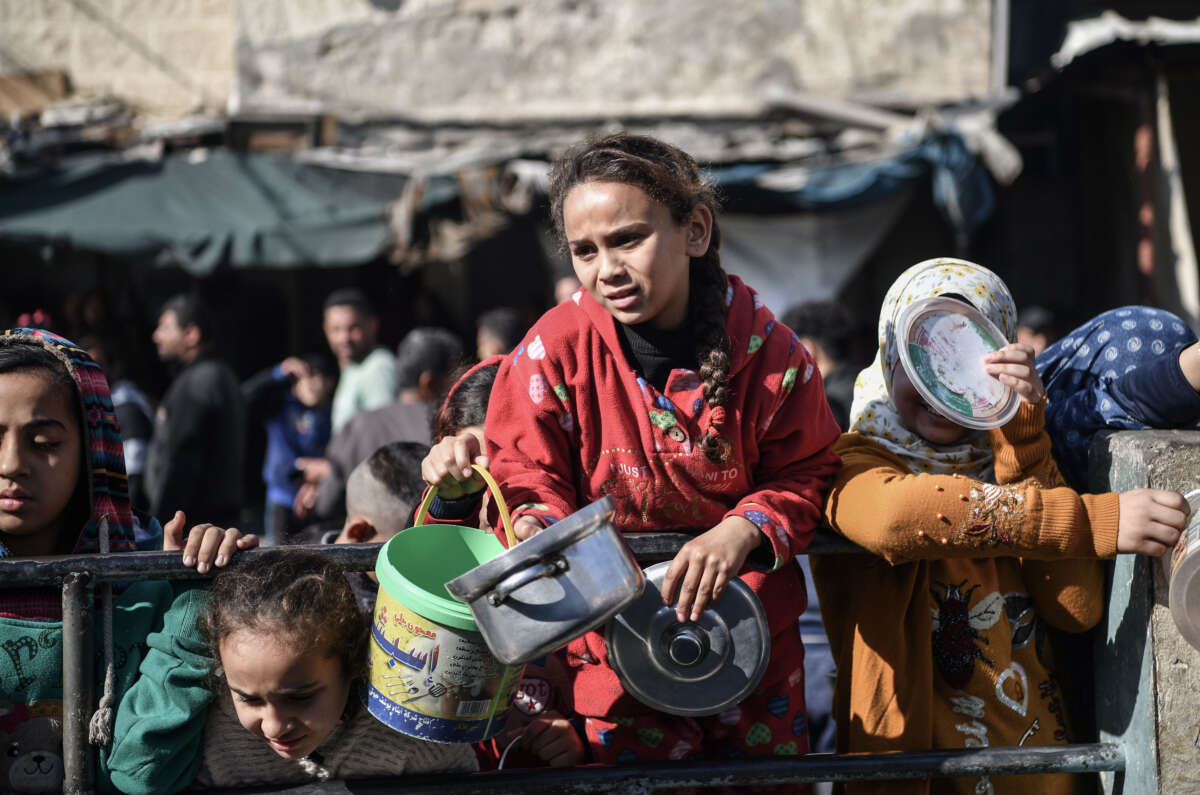 Palestinians receive food and humanitarian aid as Israeli airstrikes continue in Rafah, Gaza, on December 19, 2023.