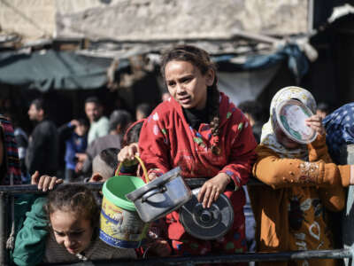 Palestinians receive food and humanitarian aid as Israeli airstrikes continue in Rafah, Gaza, on December 19, 2023.