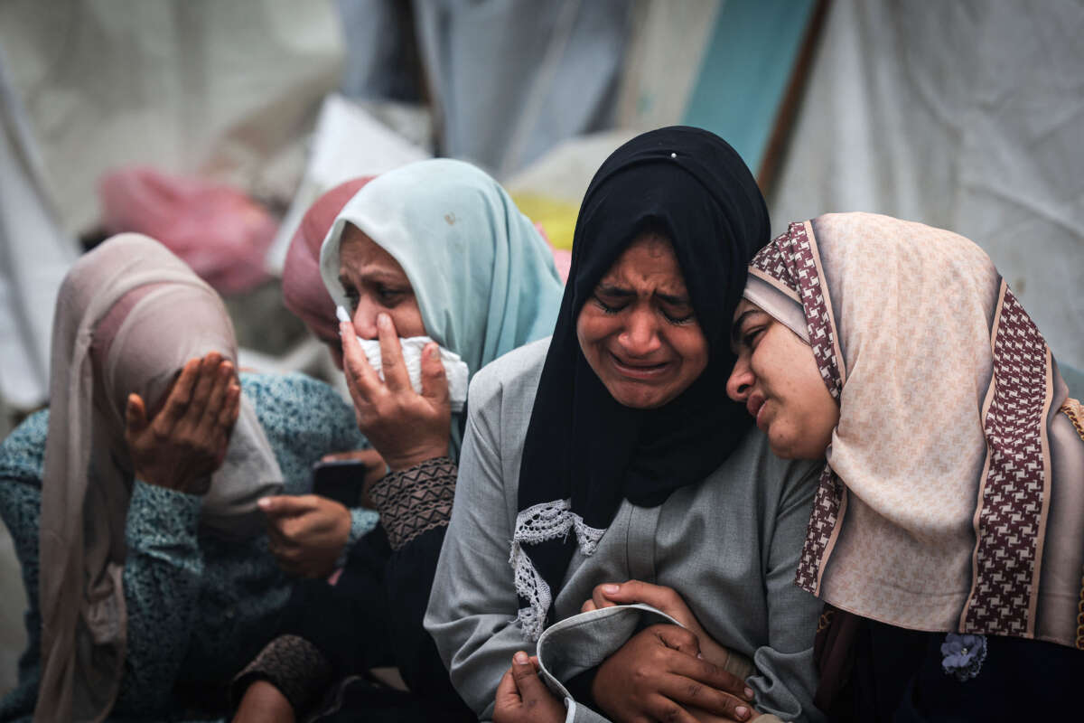 Palestinians mourn their relatives, killed in an overnight Israeli strike on the Al-Maghazi refugee camp, during a mass funeral at the Al-Aqsa hospital in Deir Al-Balah, in the southern Gaza Strip, on December 25, 2023.