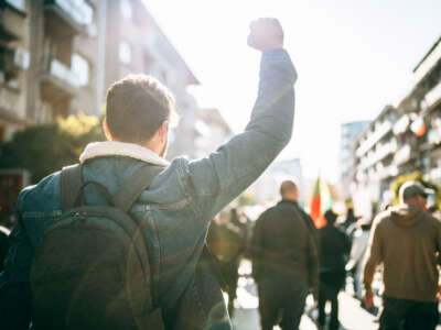 Young man with a raised fist protesting in the street