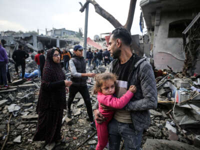 Palestinians search through rubble for survivors following Israeli strikes on the al-Maghazi refugee camp in the central Gaza Strip on December 25, 2023.