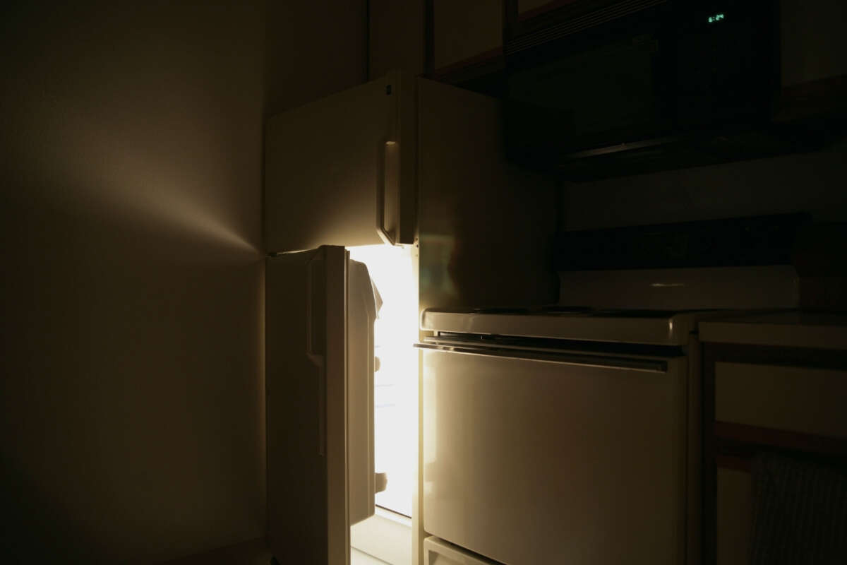 Refrigerator door opens in dark kitchen