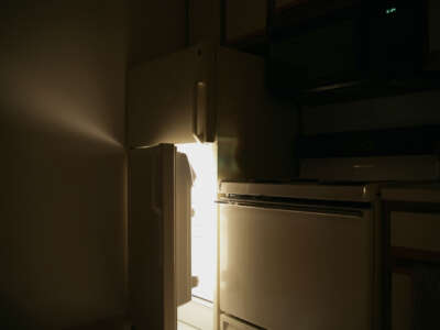 Refrigerator door opens in dark kitchen