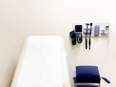 access to medical care: wall-mounted medical diagnostic equipment beside standard patient examination chair