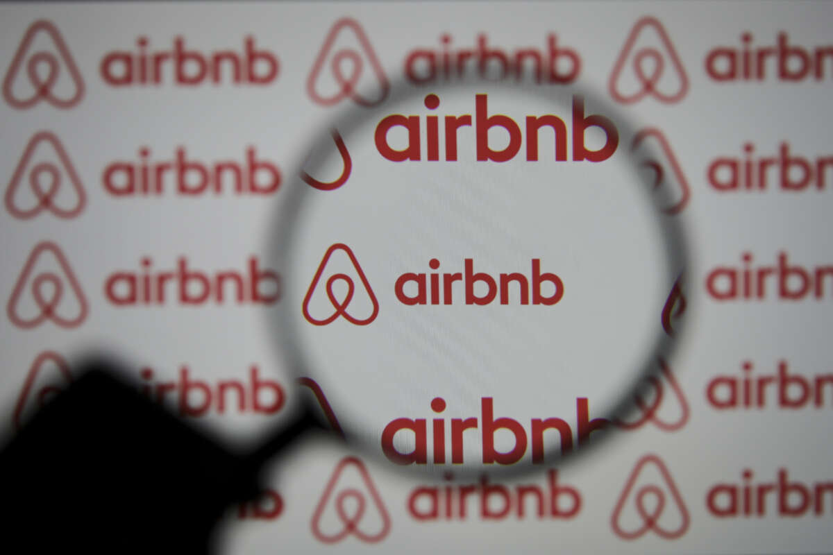A shadowy magnifying glass illuminates the airbnb logo