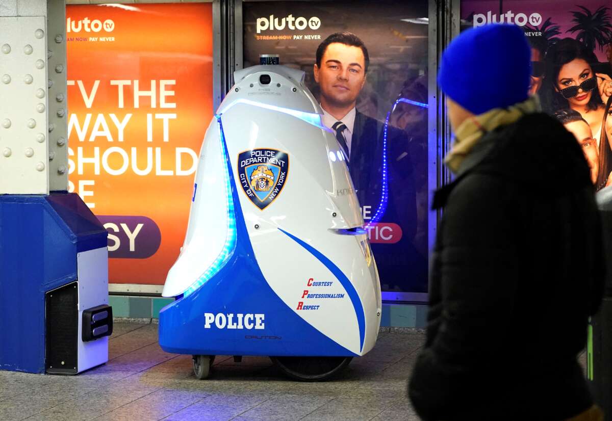 Man walks past police robot in NYC subway station