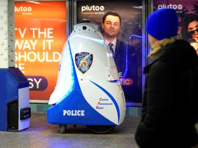 Un hombre pasa junto a un robot policial en una estación de metro de Nueva York
