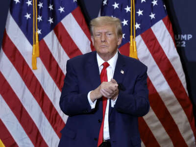Former president and 2024 presidential hopeful Donald Trump gestures at the end of a campaign event in Waterloo, Iowa, on December 19, 2023.