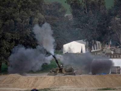 An Israeli tank fires shells