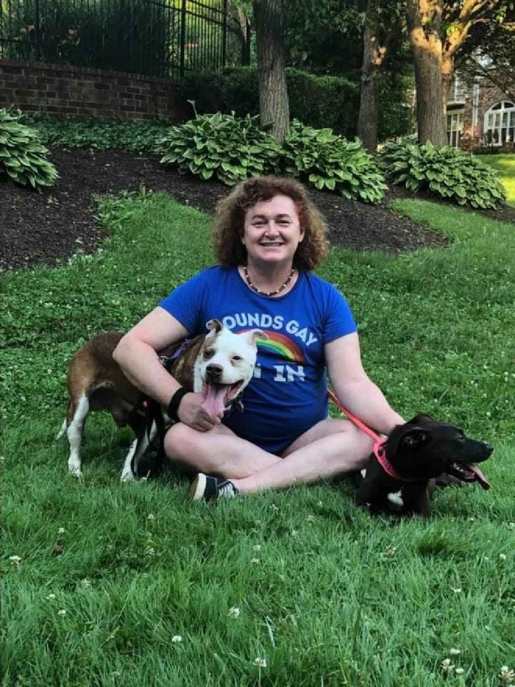 Meghan Lewis is pictured sitting with two dogs.