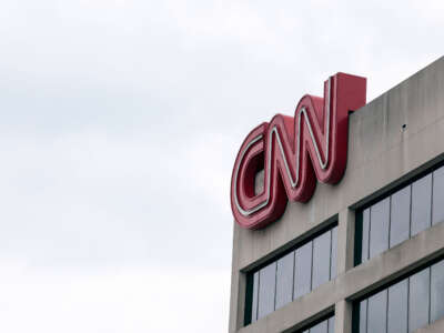 People walk by the world headquarters for the Cable News Network (CNN) on March 15, 2022, in Atlanta, Georgia.