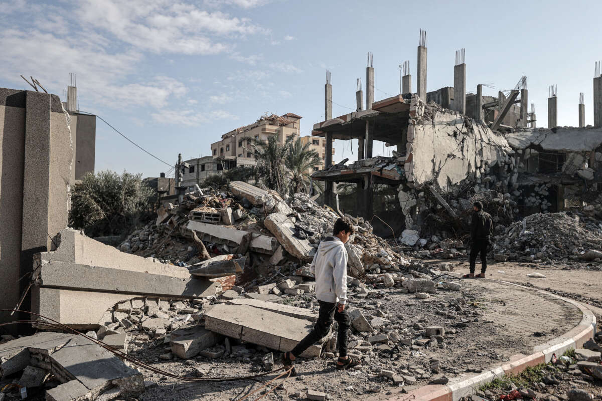 Palestinians are seen next to the rubble of a buildings destroyed by Israeli attacks in Deir al-Balah, Gaza, on January 5, 2024.