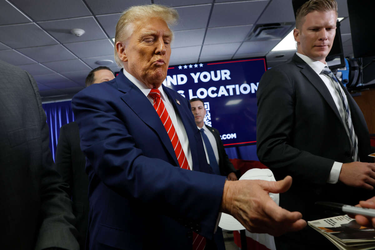 Former President Donald Trump signs autographs for guests after speaking at his campaign event on January 6, 2024, in Newton, Iowa.