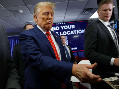 Former President Donald Trump signs autographs for guests after speaking at his campaign event on January 6, 2024, in Newton, Iowa.