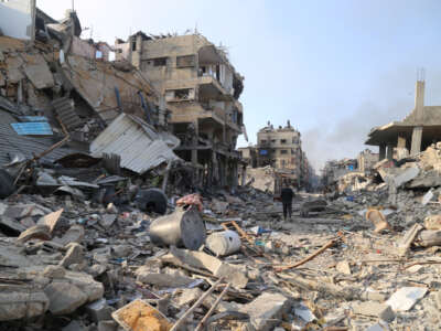 A man walks among the rubble of destroyed buildings in the northern Gaza Strip town of Beit Lahia, on January 8, 2024.