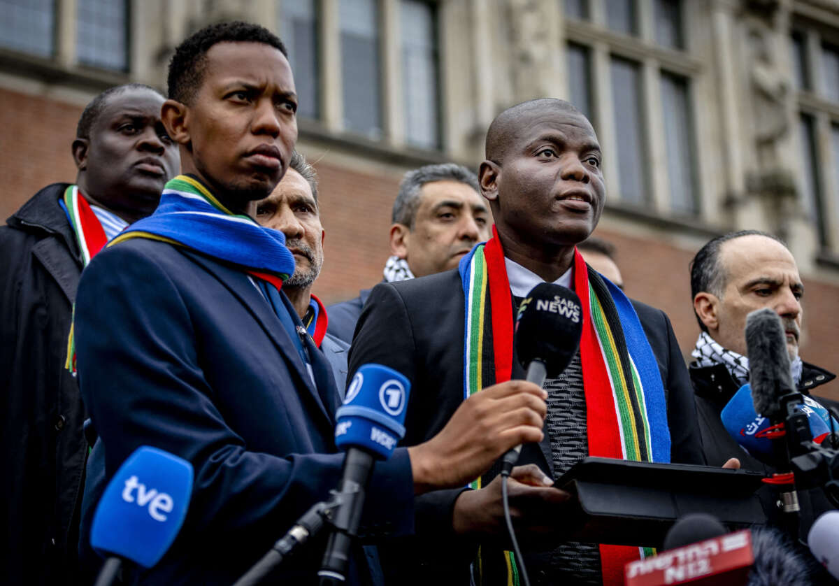 South Africa's Minister of Justice Ronald Lamola (right) delivers remarks to journalists outside the International Court of Justice after the first day of hearings on the genocide case against Israel brought by South Africa, at The Hague, on January 11, 2024.