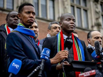 South Africa's Minister of Justice Ronald Lamola (right) delivers remarks to journalists outside the International Court of Justice after the first day of hearings on the genocide case against Israel brought by South Africa, at The Hague, on January 11, 2024.
