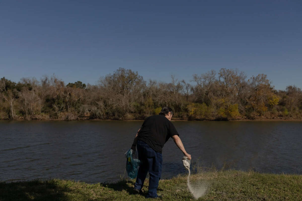 Don Green's stepson, Jerry Barker, spreads Green's and Green's dog's ashes in the yard of Green's former home in Freeport, Texas during a celebration of life on December 16, 2023.