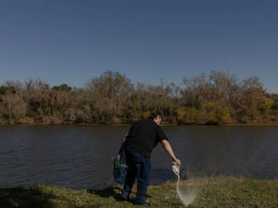 Don Green's stepson, Jerry Barker, spreads Green's and Green's dog's ashes in the yard of Green's former home in Freeport, Texas during a celebration of life on December 16, 2023.