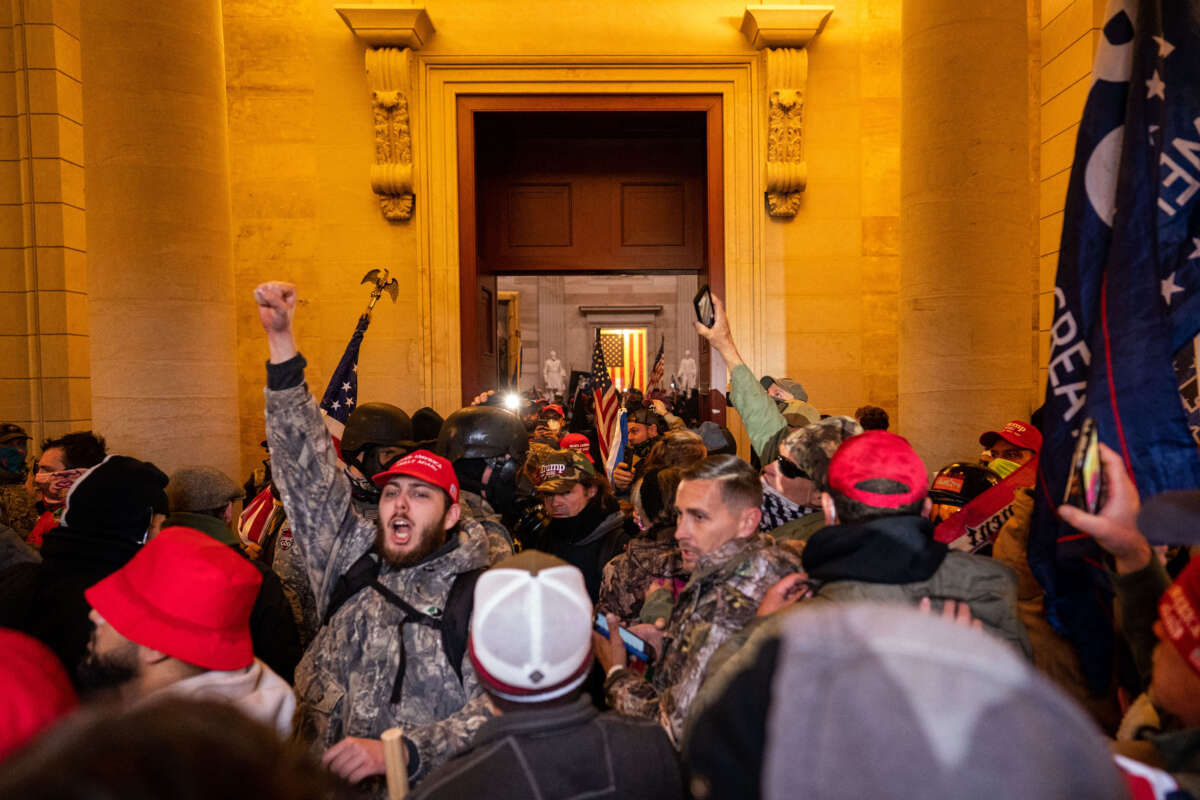 Trump supporters breach through the Columbus doors as they clash with law enforcement on the west steps / inauguration stage of the U.S. Capitol on January 6, 2021, in Washington, D.C.