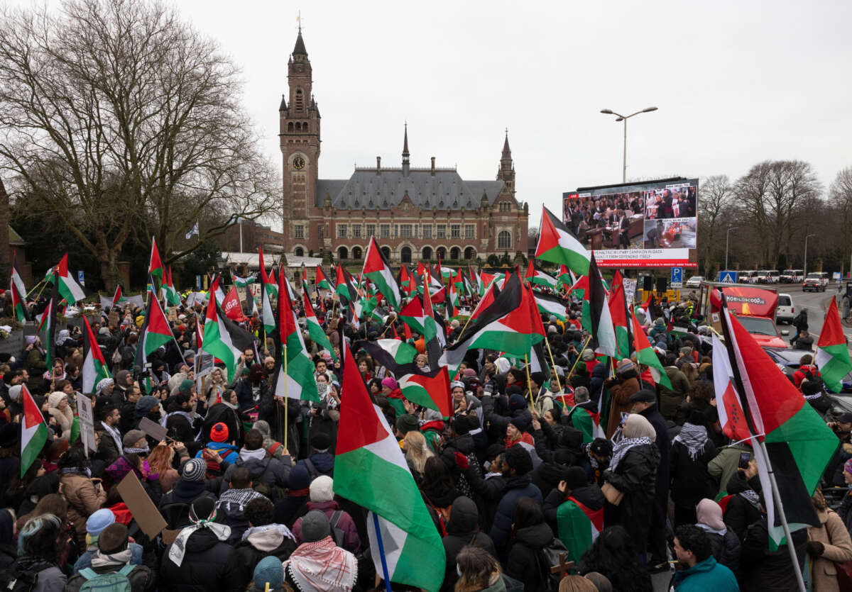 Pro-Palestinian protesters watch the court proceedings on a large TV screen in front of the International Court of Justice on January 12, 2024, in The Hague, Netherlands.