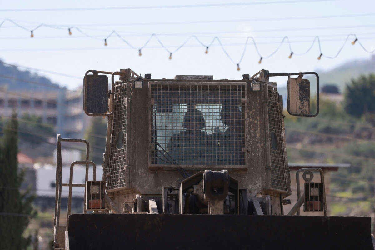An Israeli forces bulldozer drives down a road during a raid on al-Faraa camp for Palestinian refugees near Tubas city in the occupied West Bank on January 13, 2024.