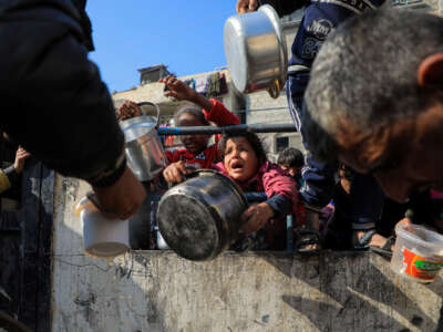 Children wait for food relief in the southern Gaza Strip city of Rafah, on December 31, 2023.