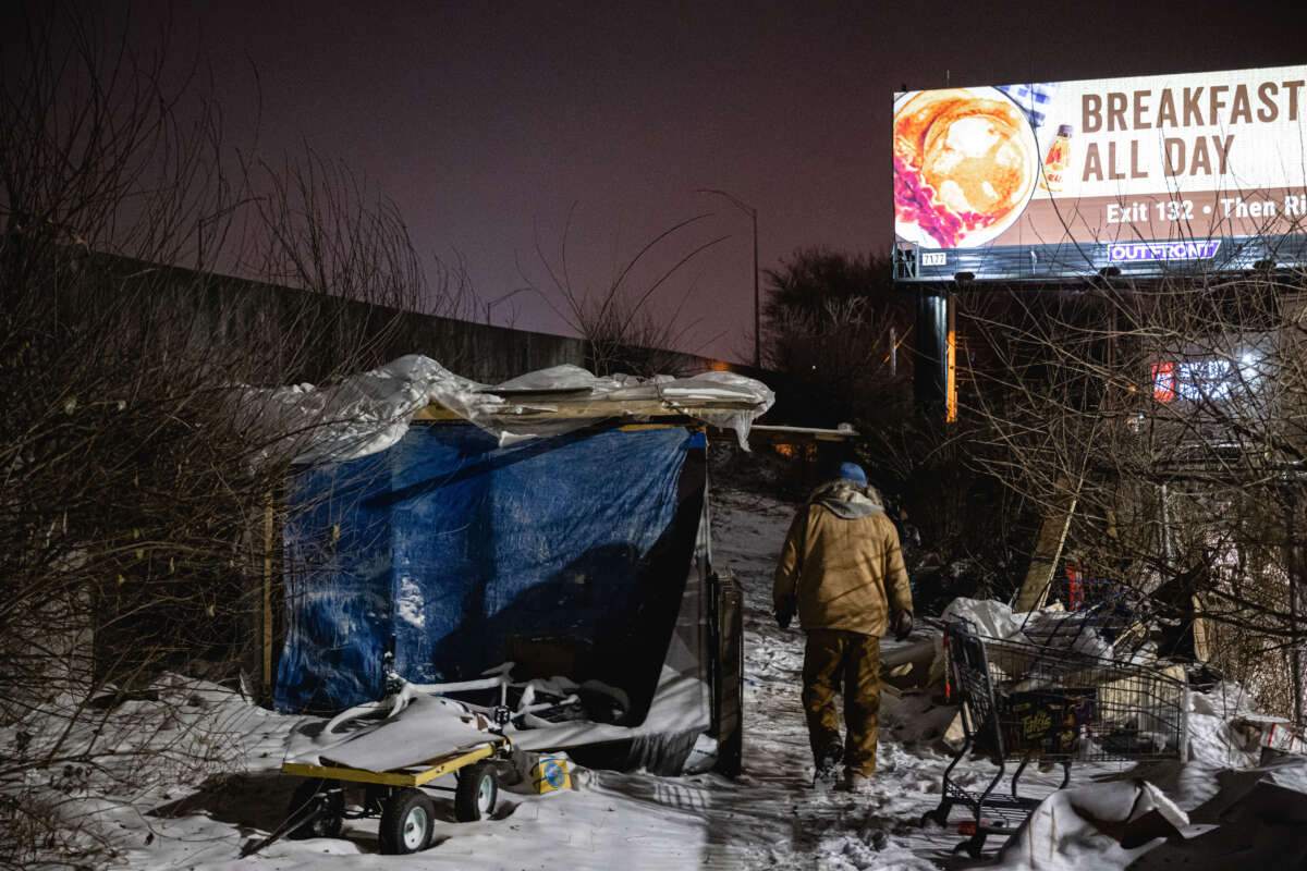 An outreach worker delivers supplies to people living in a homeless camp on December 23, 2022, in Louisville, Kentucky.