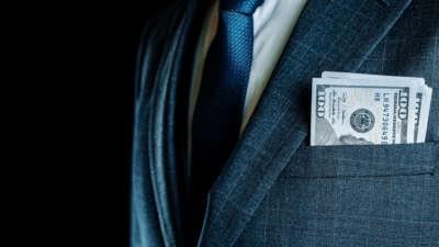 CEO / businessman with cash in coat pocket