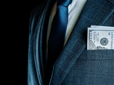 CEO / businessman with cash in coat pocket