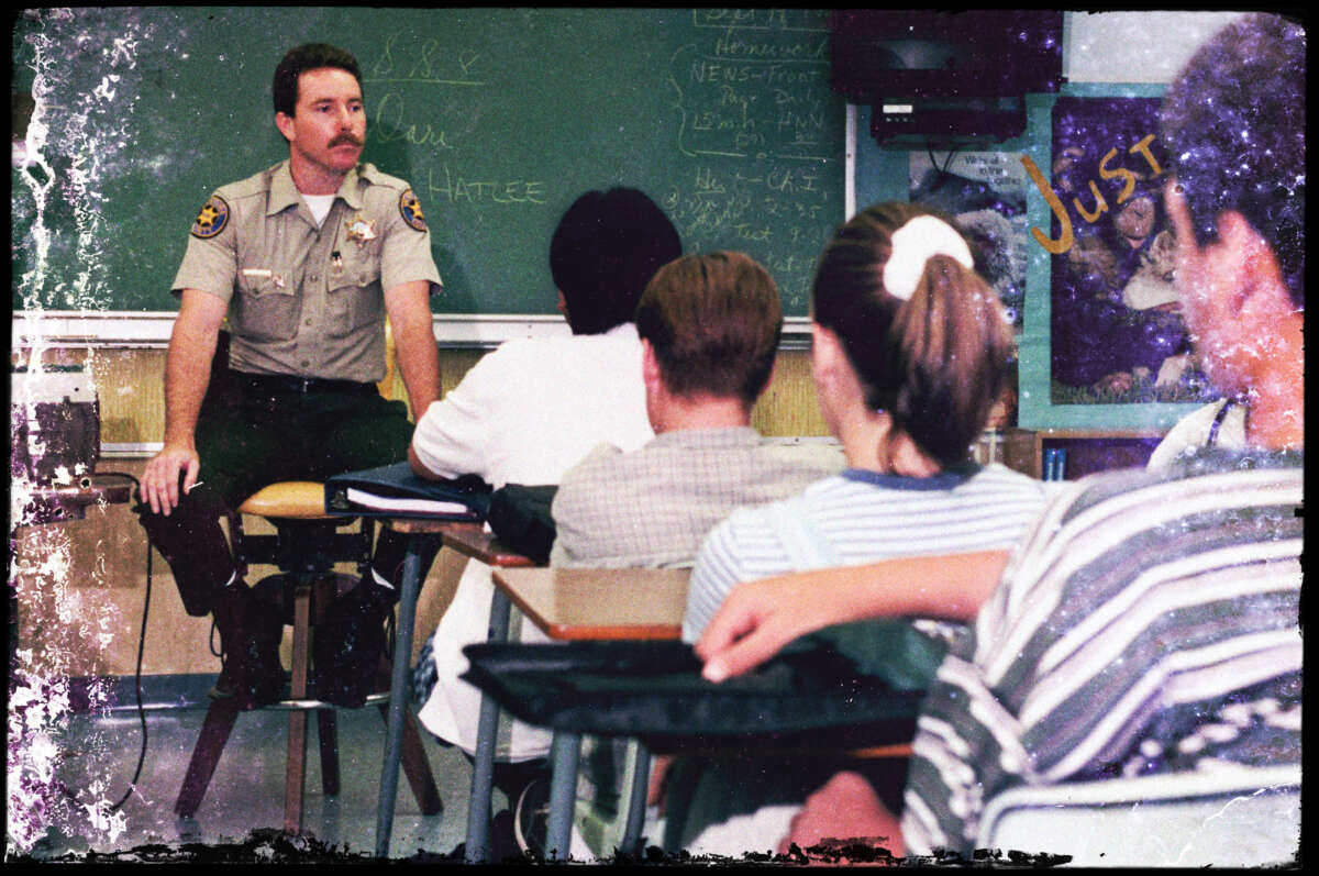 A sheriff's deputy speaks with students about the D.A.R.E program at Colina Middle School in Thousand Oaks, California, on September 19, 1996.