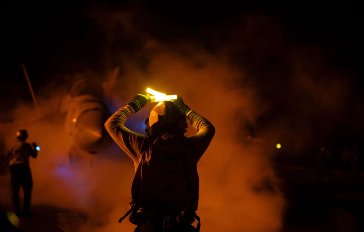 Staff hold lights to signal military aircrafts as U.S. Central Command forces alongside U.K. Armed Forces, with support from Australia, Bahrain, Canada and the Netherlands, as they conduct strikes on Houthi targets in Yemen, on January 23, 2024.