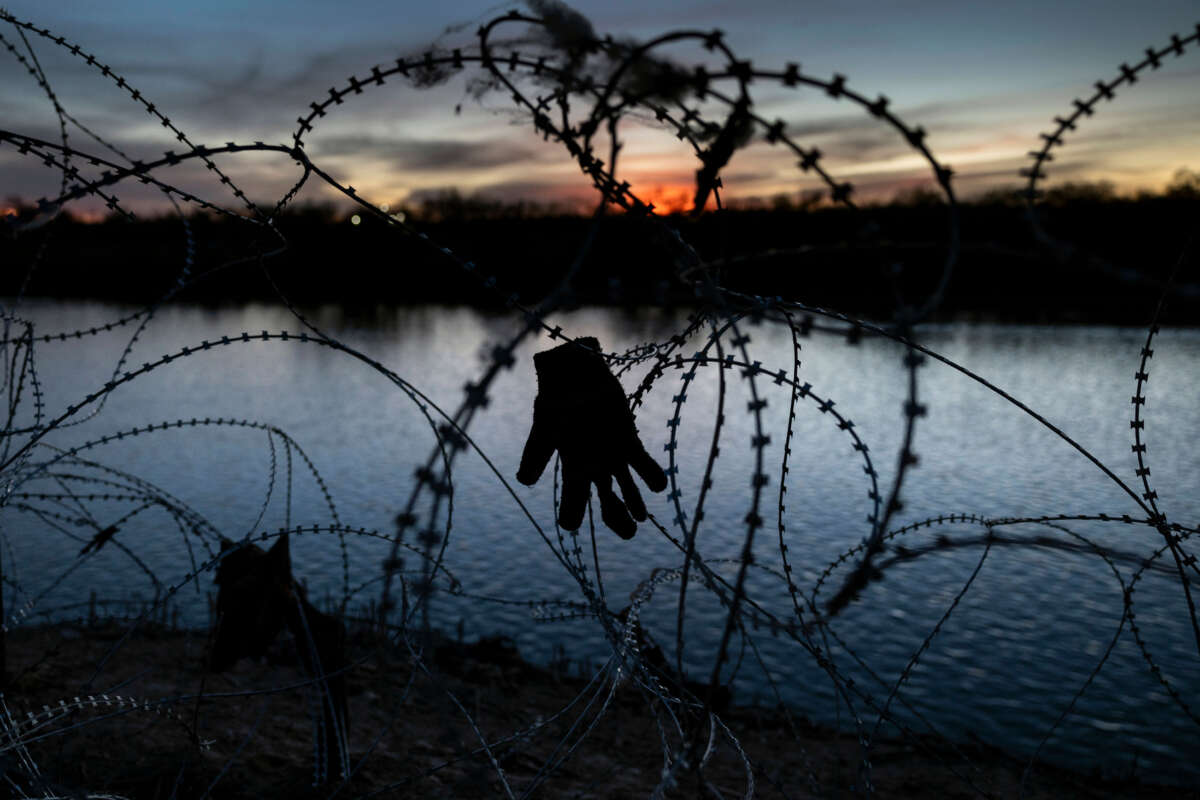 A glove hangs caught in razor wire atop the bank of the Rio Grande on January 9, 2024, in Eagle Pass, Texas.