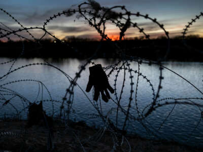 A glove hangs caught in razor wire atop the bank of the Rio Grande on January 9, 2024, in Eagle Pass, Texas.