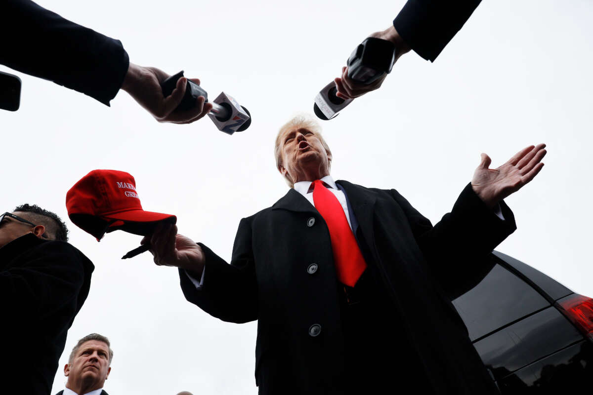 Former President Donald Trump talks to reporters while visiting the polling site at Londonderry High School on January 23, 2024, in Londonderry, New Hampshire.
