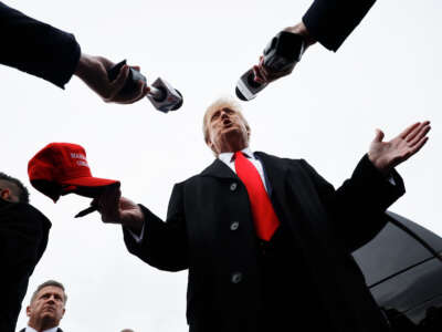 Former President Donald Trump talks to reporters while visiting the polling site at Londonderry High School on January 23, 2024, in Londonderry, New Hampshire.