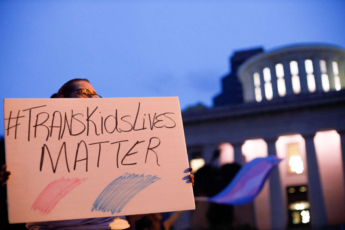 A transgender rights advocate holds a sign outside the Ohio Statehouse during a rally in Columbus, Ohio, on June 24, 2021.
