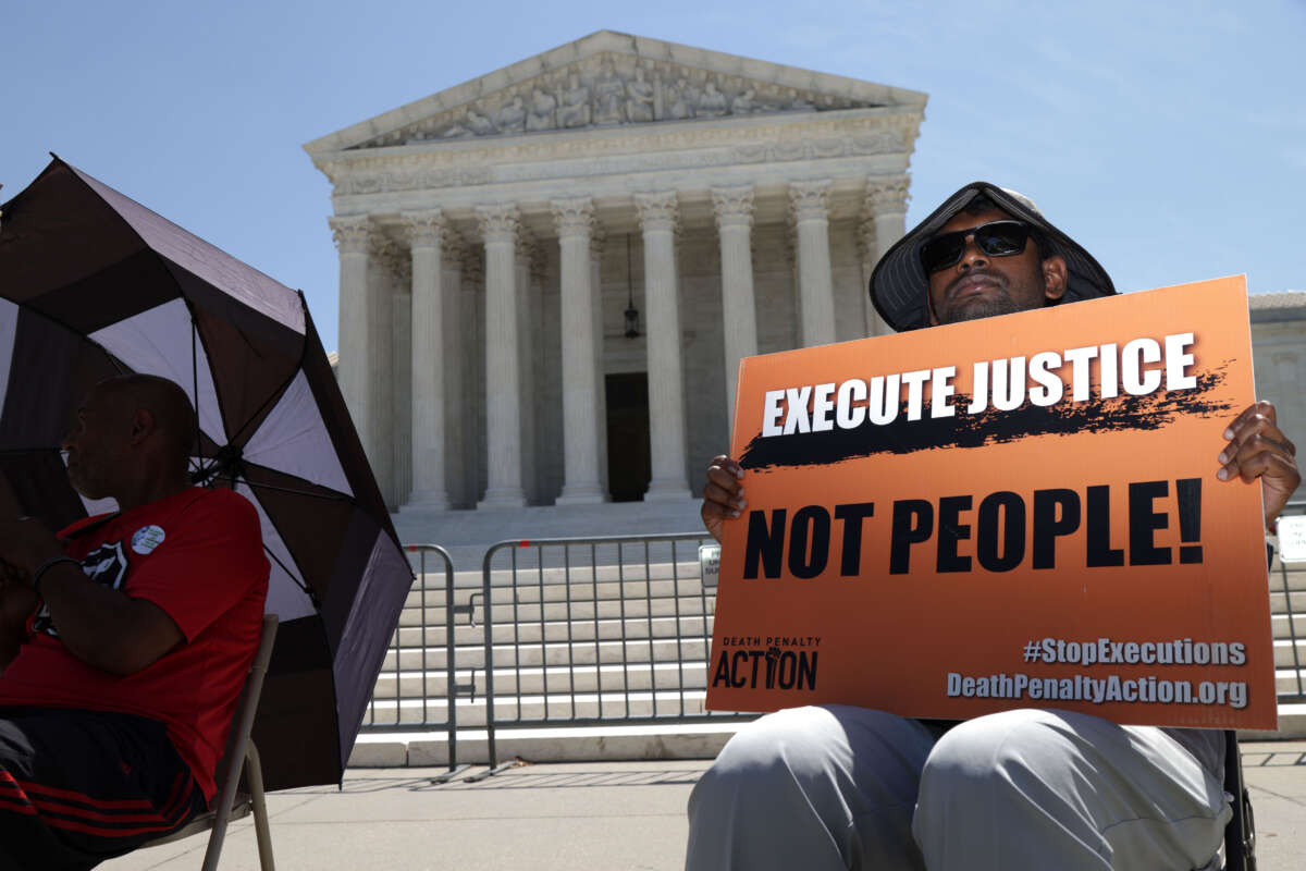 A protester holds a sign that reads 'Execute Justice Not People!' as he participates in a vigil against the death penalty in front of the U.S. Supreme Court on June 29, 2021, in Washington, D.C.