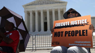 A protester holds a sign that reads 'Execute Justice Not People!' as he participates in a vigil against the death penalty in front of the U.S. Supreme Court on June 29, 2021, in Washington, D.C.