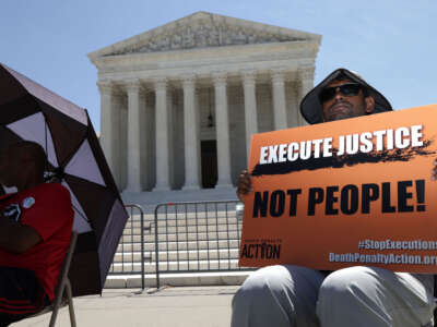 A protester holds a sign that reads 'Execute Justice Not People!' as he participates in a vigil against the death penalty in front of the U.S. Supreme Court on June 29, 2021, in Washington, D.C.