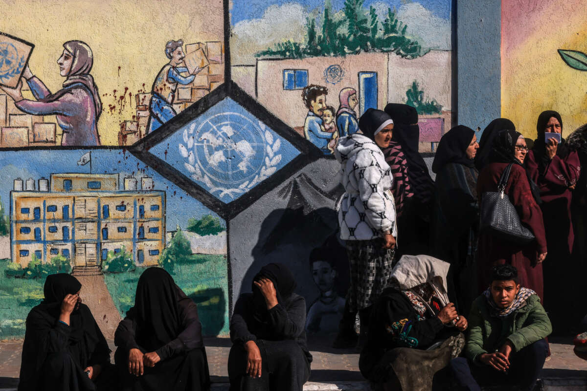 Displaced Palestinians queue to receive aid in front of the United Nations Relief and Works Agency for Palestine Refugees (UNRWA) center in Rafah in the southern Gaza Strip on January 28, 2024.