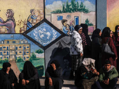 Displaced Palestinians queue to receive aid in front of the United Nations Relief and Works Agency for Palestine Refugees (UNRWA) center in Rafah in the southern Gaza Strip on January 28, 2024.