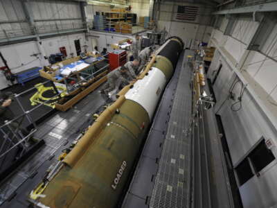 U.S. Air Force airman install a cable raceway on an intercontinental ballistic missile