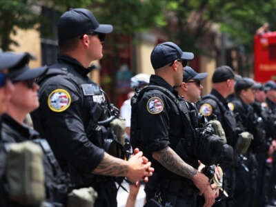 Philadelphia police officers stand guard as people protest the Moms for Liberty Joyful Warriors national summit outside the Philadelphia Marriott Downtown on July 1, 2023, in Philadelphia, Pennsylvania.