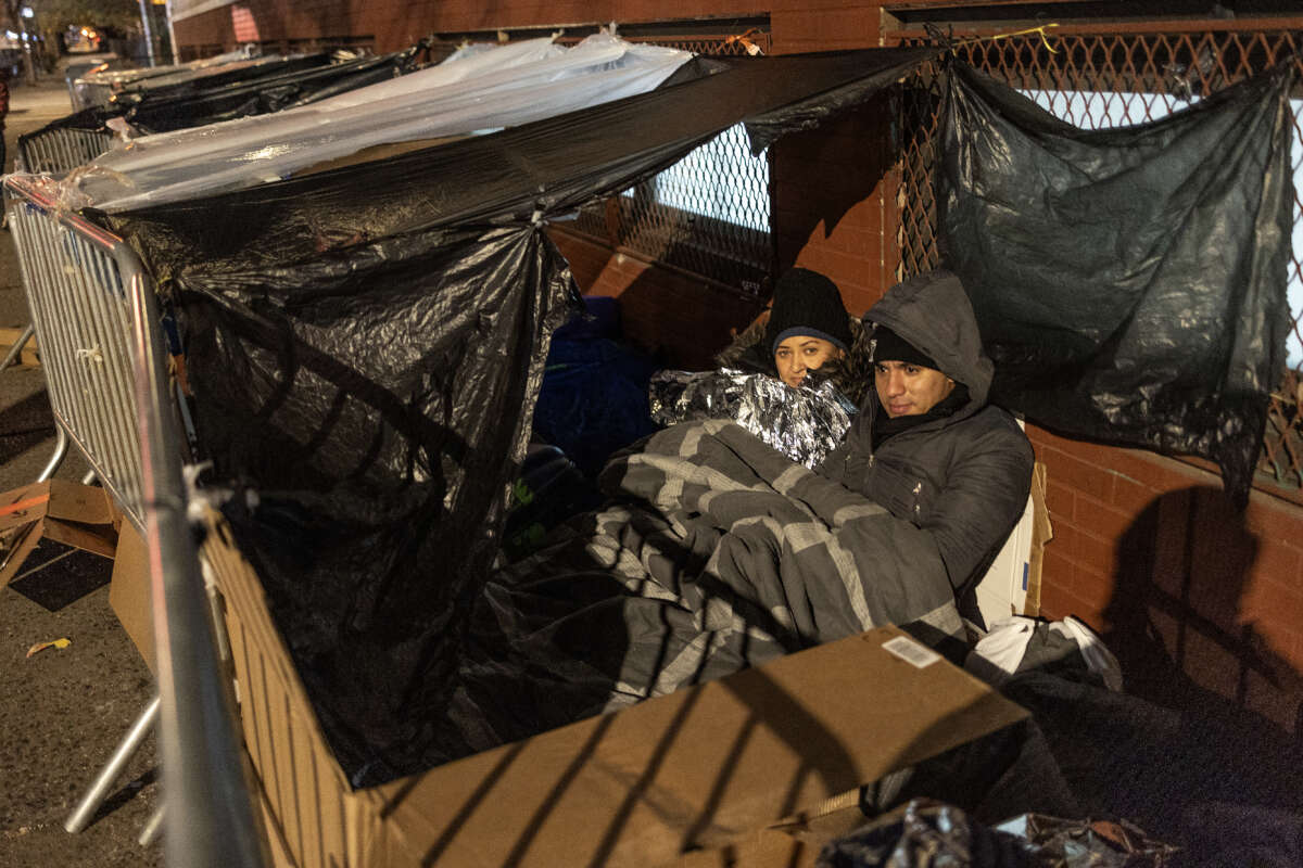 Migrants wait in a long line overnight hoping to receive a placement in a city shelter on December 6, 2023, in New York City.