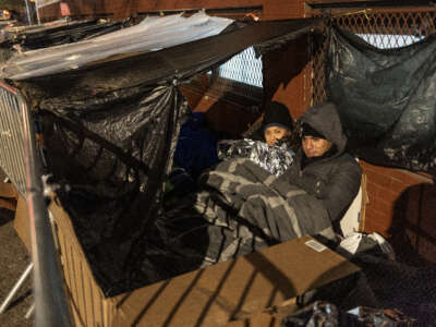 Migrants wait in a long line overnight hoping to receive a placement in a city shelter on December 6, 2023, in New York City.