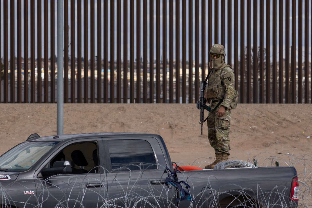 A member of the Texas National Guard watches over the border wall between Mexico and the United States, on December 23, 2023.