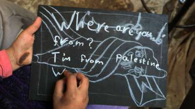 A student writes down "I am from Palestine" at a temporary classroom in the southern Gaza Strip city of Rafah, on December 28, 2023.