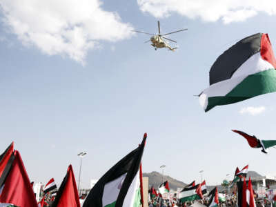 A Yemeni helicopter flies in the air while people protest in solidarity with Palestinians and against the Israeli war in Gaza and the recently-created U.S. maritime coalition in the Red Sea, on January 5, 2024, in Sana'a, Yemen.