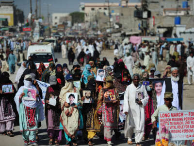 Baloch families carry photographs of their missing loved ones in a march against government repression